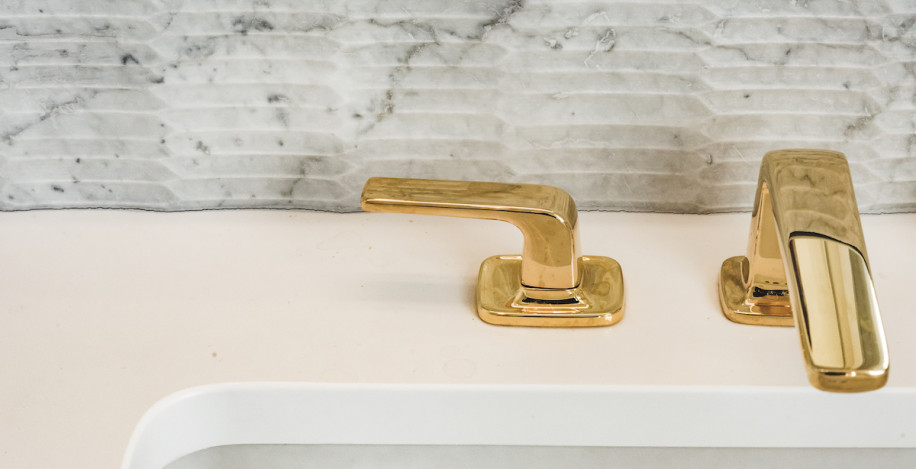 gold-sink-faucet-handles-details-marble-backsplash
